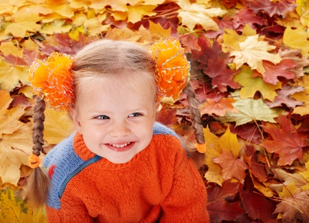 Girl child in autumn orange leaves. Outdoor.の写真素材