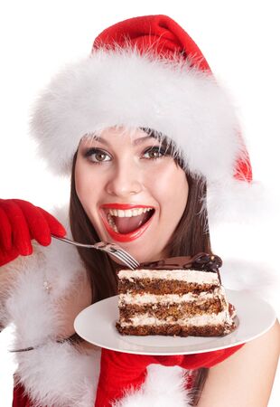 Christmas girl in red santa hat eating cake on plate. Isolated.の写真素材