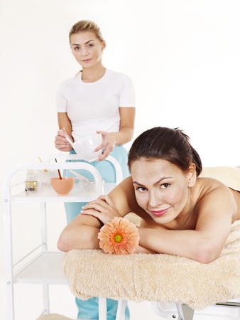 Beautician applying  facial mask by young woman.の写真素材
