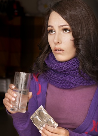Young woman having flu takes pills.の写真素材