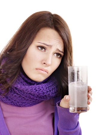 Young woman holding glass of water and taking pills  having  flue.の写真素材