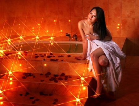 Woman sitting on edge of bath tub.の写真素材