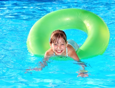 Children sitting on inflatable ring in swimming pool.の写真素材