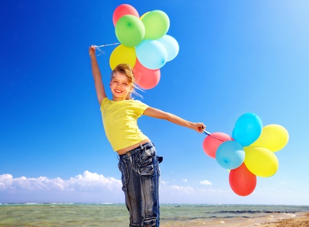 Child playing with balloons at the beach.の写真素材