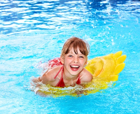 Little girl swimming on inflatable beach mattress.の写真素材
