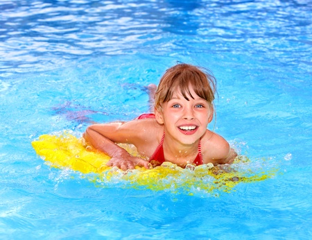 Little girl swimming on inflatable beach mattress.の写真素材