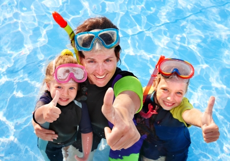 Children with mother  in swimming pool learning snorkeling.の写真素材