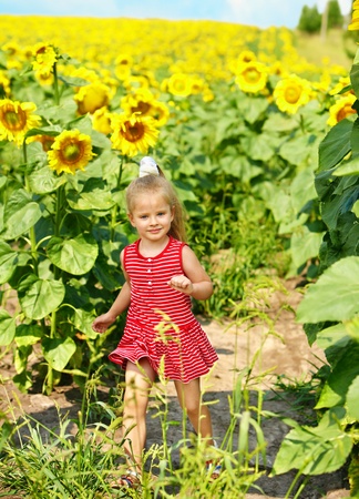 Child holding sunflower outdoor.の写真素材