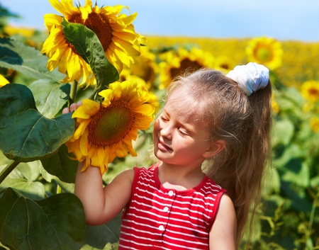 Child holding sunflower outdoor.の写真素材