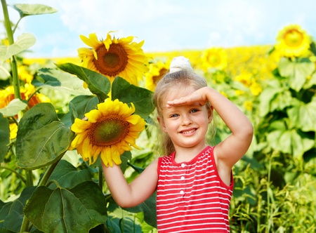 Child holding sunflower outdoor.の写真素材