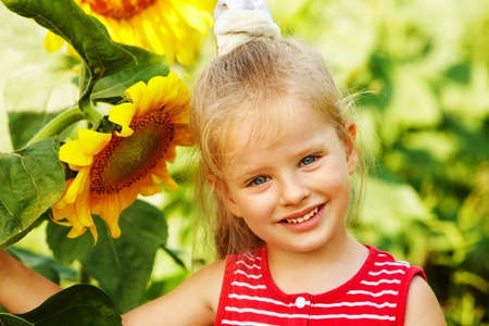 Child holding sunflower outdoor.の写真素材