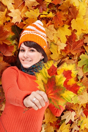 Young woman in autumn orange leaves. Outdoor.の写真素材