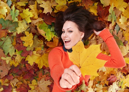 Young woman in autumn orange leaves. Outdoor.の写真素材