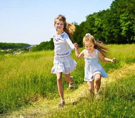 Group children running across green grass outdoor. の写真素材