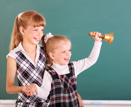 Happy schoolchildren in classroom near blackboard.の写真素材