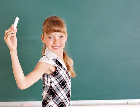 Happy schoolchild writing on blackboard.の写真素材