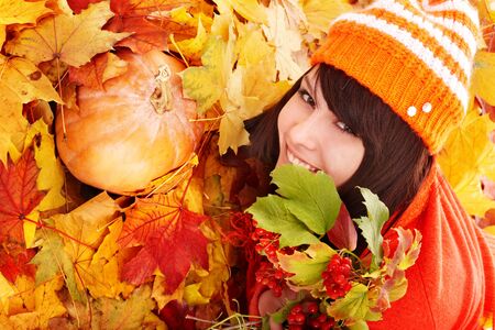 Young woman in autumn orange leaves with pumpkin.. Outdoor.の写真素材