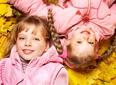 Children in autumn orange leaves. Outdoor.の写真素材