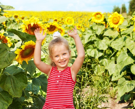 Child holding sunflower outdoor.の写真素材