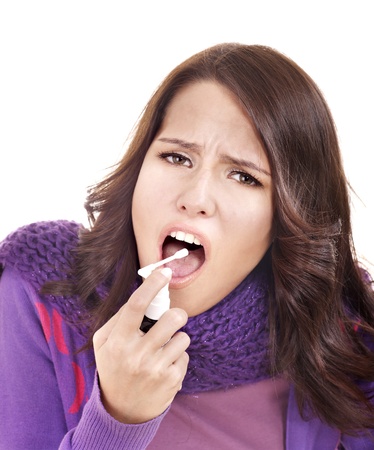 Young woman using throat spray.の写真素材