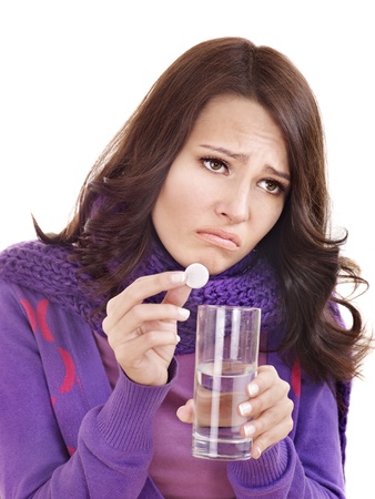 Young woman holding glass of water and taking pills  having  flue.の写真素材