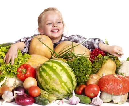 Little girl with vegetable on kitchen.の写真素材