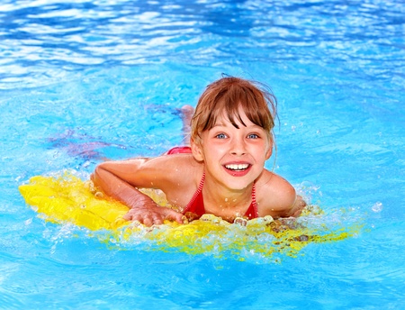 Little girl swimming on inflatable beach mattress.の写真素材