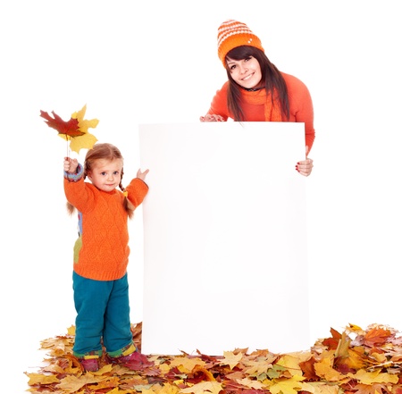 Happy family with child on autumn leaves holding banner.の写真素材