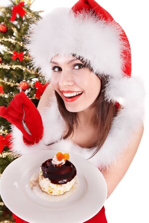 Christmas girl in red santa hat and cake on plate. Isolated.の写真素材