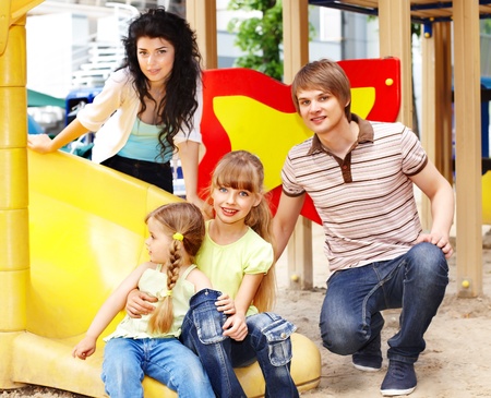 Outdoor happy family with children on slide.の写真素材