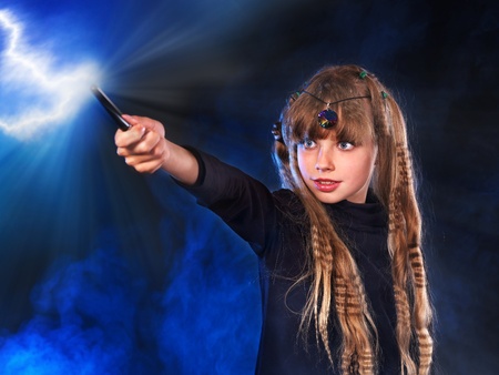 Girl in witch's hat with magic wand casting spells.の写真素材