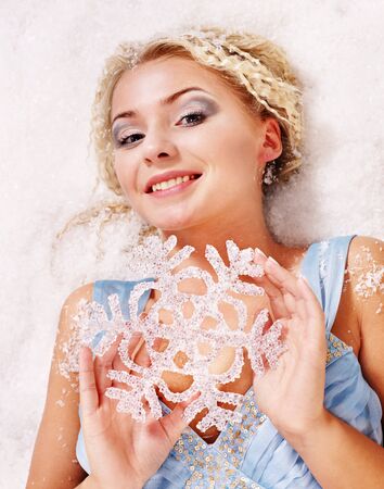 Young beautiful woman holding snowflake. Fashion studio shot.の写真素材
