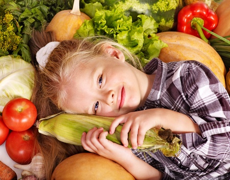 Little girl with vegetable on kitchen.の写真素材
