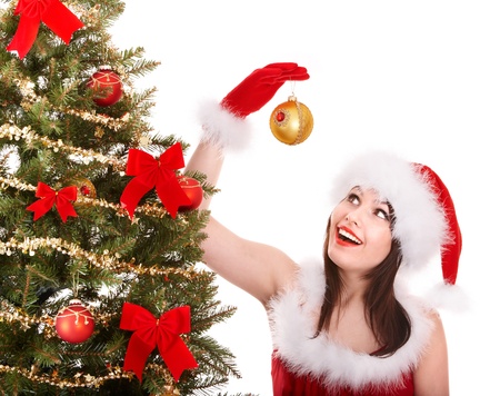 Girl in santa hat decorete christmas tree.  Isolated.の写真素材