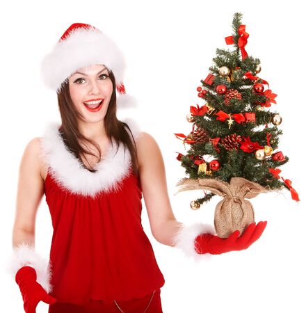 Girl in santa hat holding christmas tree. Isolated.の写真素材