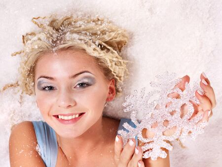 Young beautiful woman holding snowflake. Fashion studio shot.の写真素材