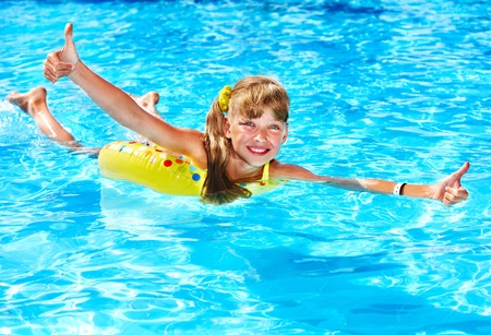 Children sitting on inflatable ring in swimming pool.の写真素材