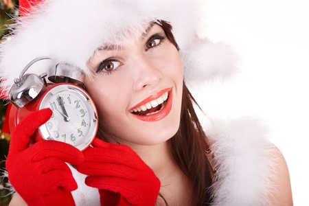 Christmas girl in santa hat holding clock.  Isolated.の写真素材