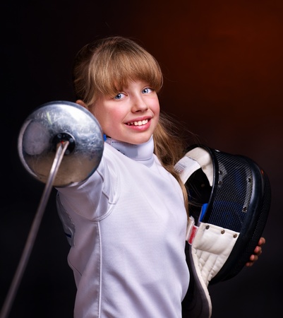 Child epee fencing lunge. Dark background.の写真素材