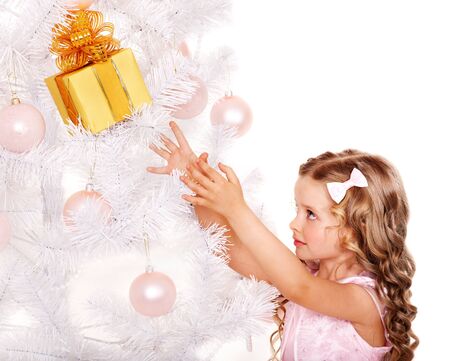 Child with gift box near white Christmas tree. Isolated.の写真素材