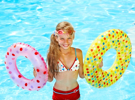 Child sitting on inflatable ring in swimming pool.の写真素材