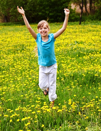 Happy little girl  running in  field.の写真素材