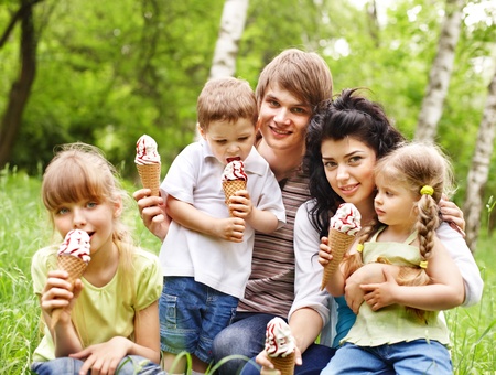 Outdoor family with three kids on green grass.の写真素材