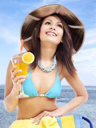 Girl in bikini drink juice through a straw.の写真素材