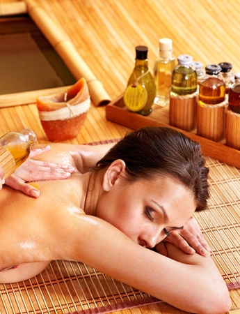 Young woman getting massage in bamboo spa.の写真素材