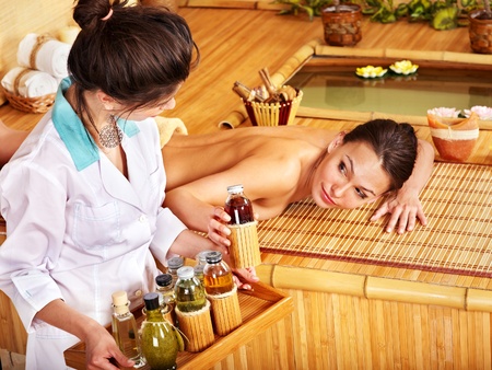 Young woman getting massage in bamboo spa.の写真素材