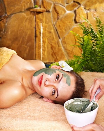 Beautiful girl having clay body mask apply by beautician.の写真素材