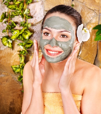 Beautiful girl having clay body mask apply by beautician.の写真素材