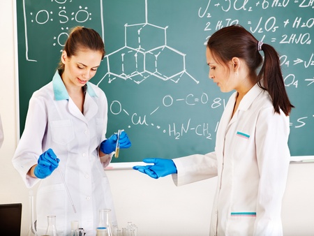 Female chemistry student with flask in classroom.の写真素材