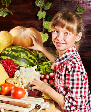 Little girl with vegetable on kitchen.の写真素材